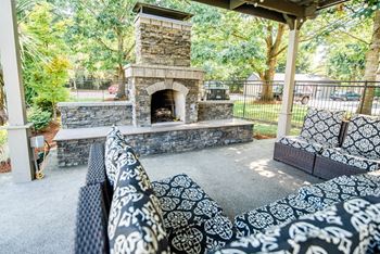 the outdoor patio has a fireplace and a seating area